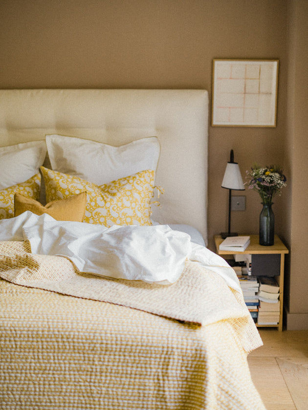 Chambre épuré avec un linge de lit jaune et blanc