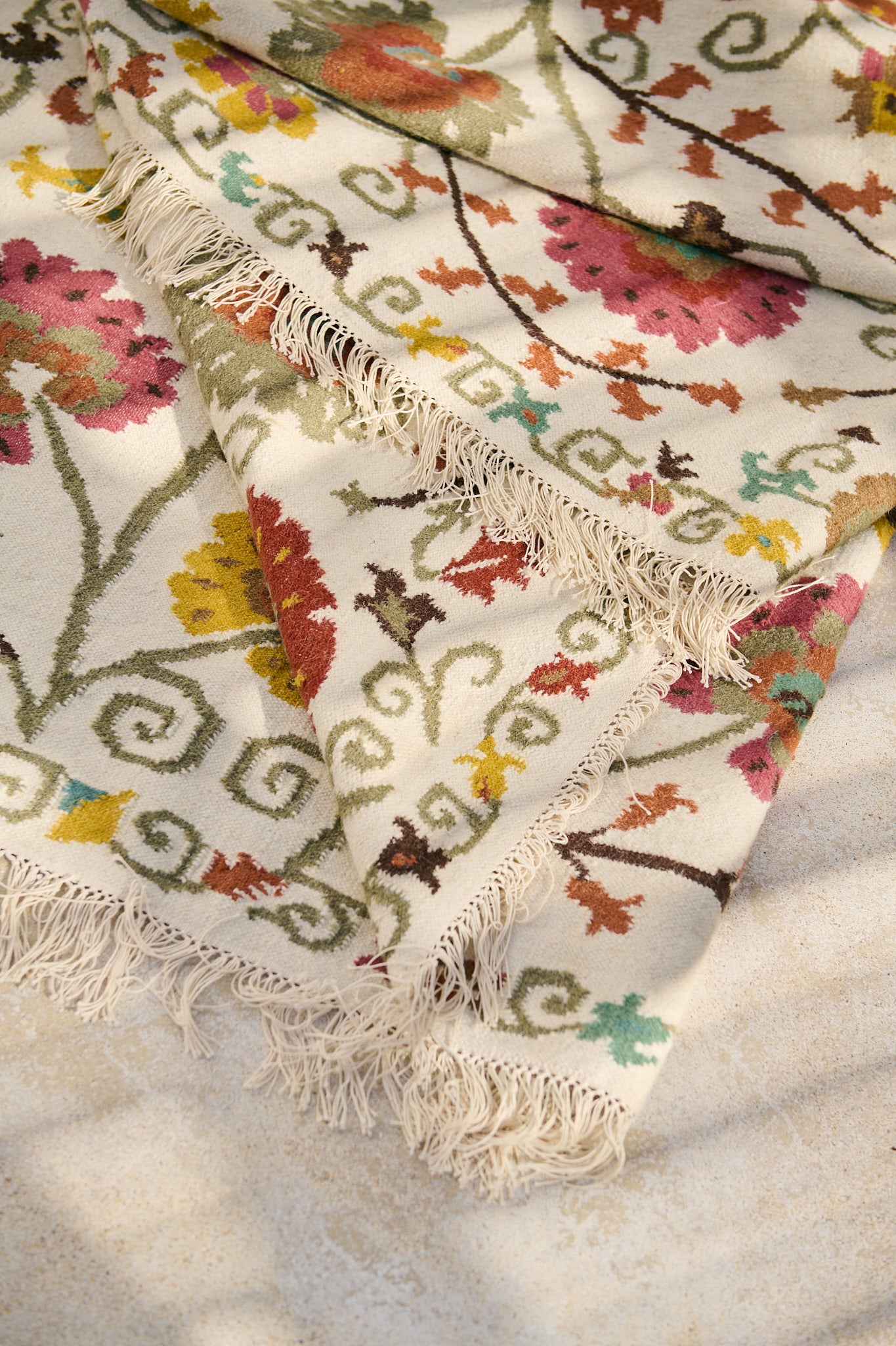 Détail des franges et des motifs fleuris du tapis Lohdi en laine