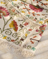 Détail des franges et des motifs fleuris du tapis Lohdi en laine