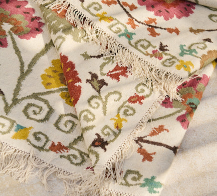 Détail des franges et des motifs fleuris du tapis Lohdi en laine