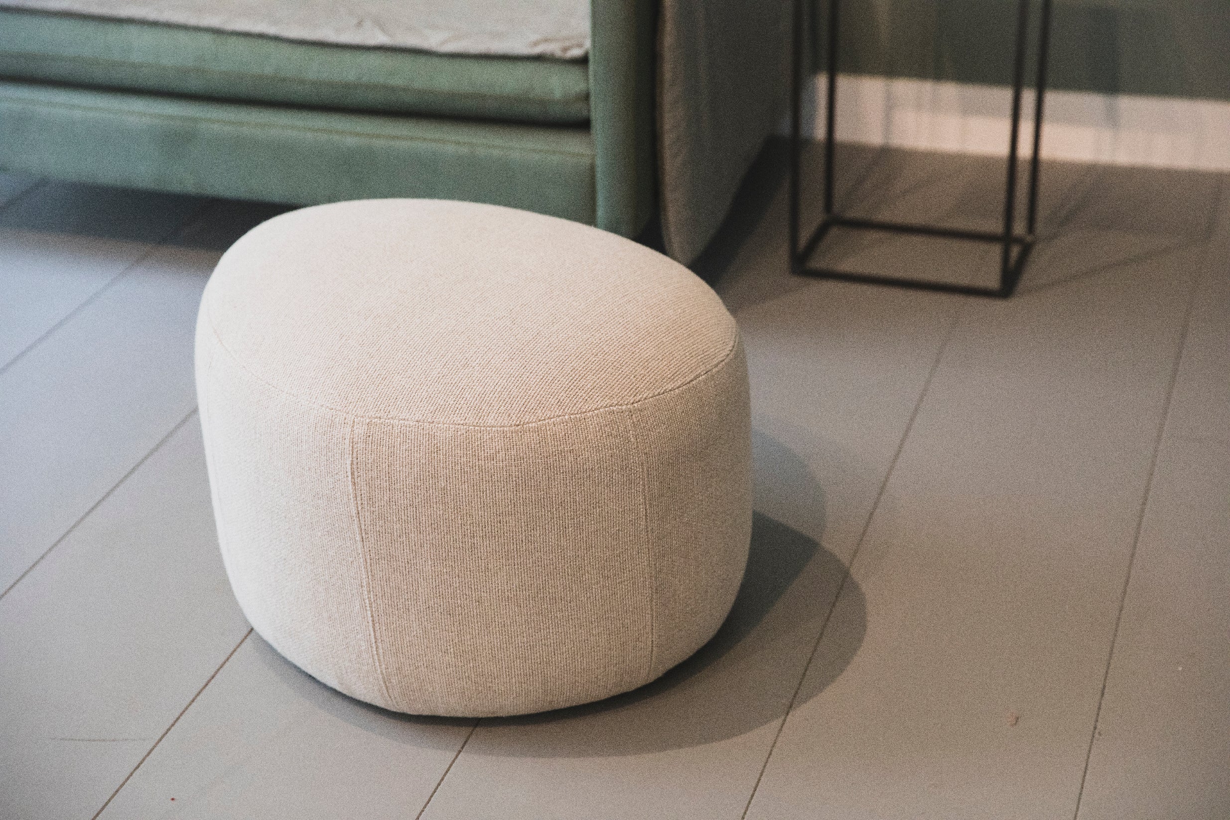 Petit pouf rond en tissu clair pour salon 
